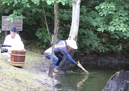 古式に則り「燃える水」をカグマで掬う（新潟県黒川村にて）